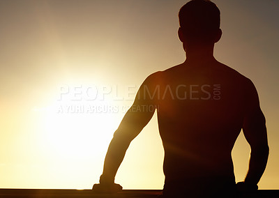 Buy stock photo A silhouette of a muscular man looking at the sunset