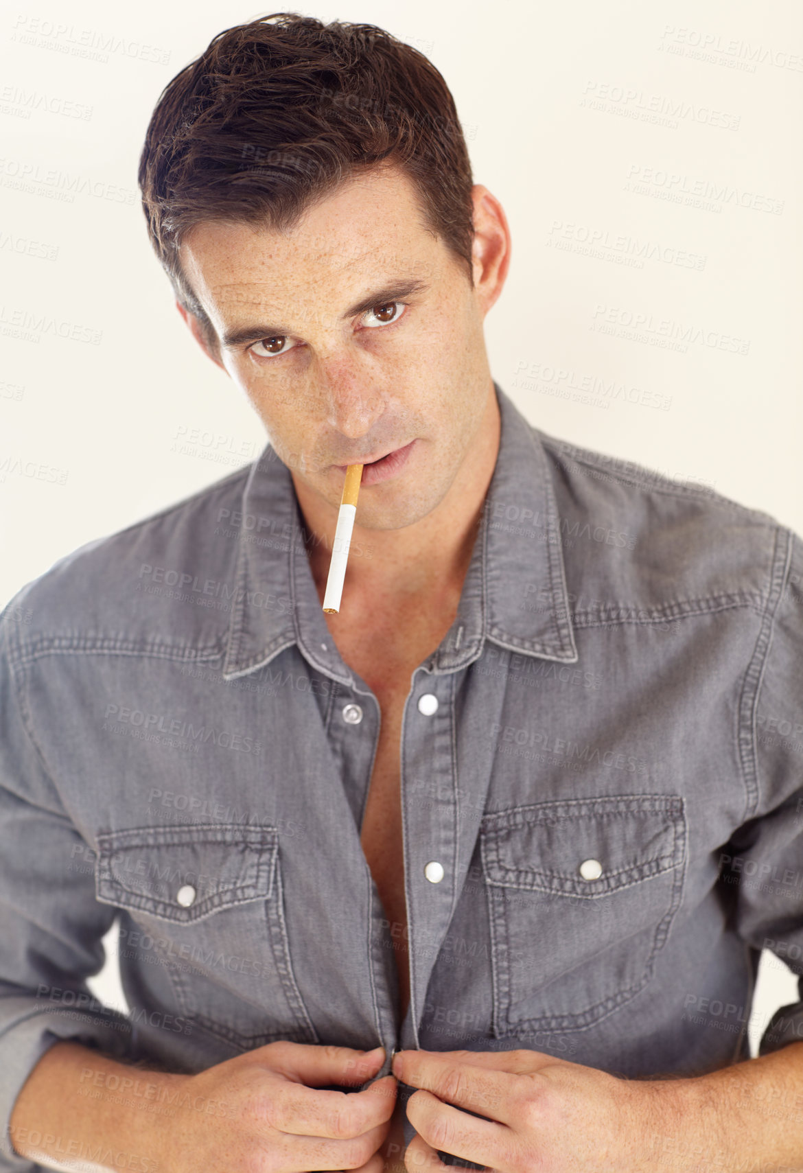 Buy stock photo Portrait of a handsome young man with a cigarette in his mouth