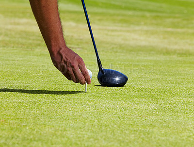 Buy stock photo Cropped shot of a golfer placing a ball on a tee