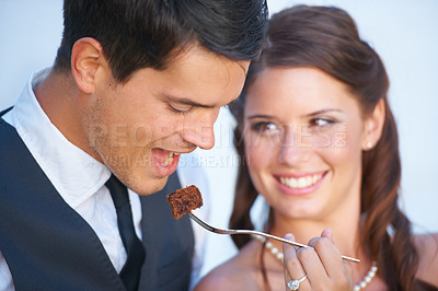 Buy stock photo Smile, wedding and couple eating cake together for celebration of love together at party. Happy, cute and young bride feed husband sweet dessert at romantic marriage ceremony or event with commitment