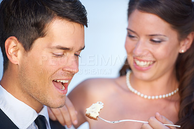 Buy stock photo Happy, wedding and couple eating cake together for celebration of love together at party. Smile, cute and young bride feed husband sweet dessert at romantic marriage ceremony or event with commitment