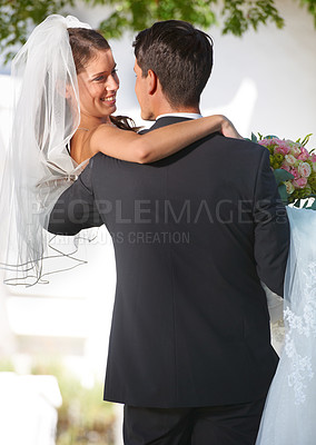 Buy stock photo Rearview shot of a groom carrying his new bride outside