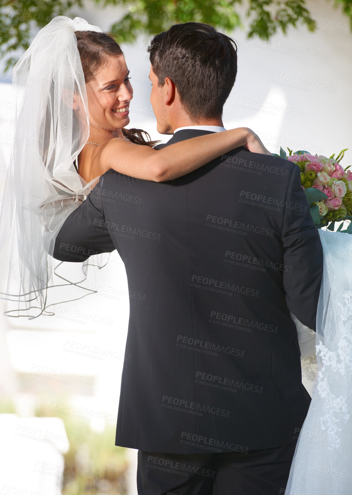 Buy stock photo Rearview shot of a groom carrying his new bride outside