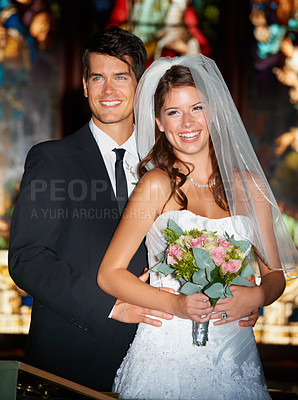 Buy stock photo Portrait of a happy newlywed couple standing in front of stained glass windows