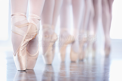Buy stock photo Cropped shot of a group of ballerinas standing in a row with their feet "en pointe"