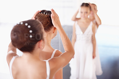 Buy stock photo Ballet, kids and help with hair in mirror of classroom, academy or gym training together. Young girl ballerina students in dance studio reflection with support, trust and learning for performance.