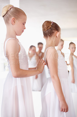 Buy stock photo Ballet, children and friends helping tie dress in classroom, academy or gym training together. Young girl ballerina students in dance studio with support, trust and learning practice for performance.