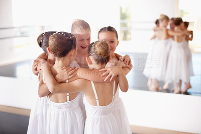 Buy stock photo Shot of a group of young ballerinas huddling together in the studio