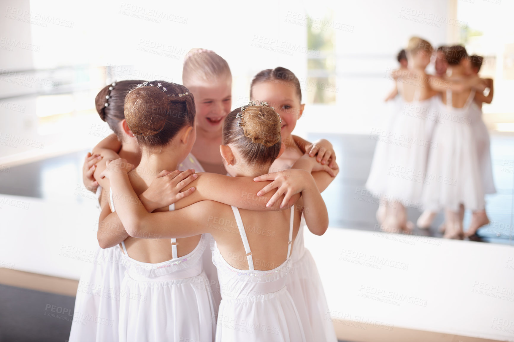 Buy stock photo Shot of a group of young ballerinas huddling together in the studio