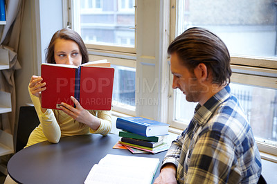 Buy stock photo Education, college and couple studying in a library, learning and reading books together. Scholarship, focus and a man and woman sitting at a university table for research, knowledge and information