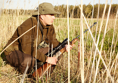 Buy stock photo Hiding, game hunter and gun of man in nature on a safari for shooting and animal spotting. Sun, outdoor and sniper with scope and male person with a hunting weapon in Africa with patience and crouch