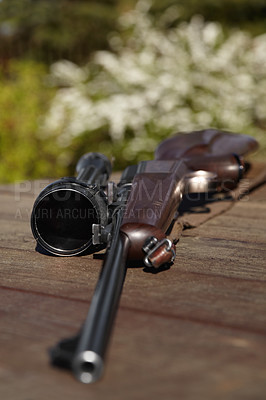 Buy stock photo Hunting, rifle and weapon with a gun on a table outdoor in nature on a game reserve or blurred background. Sports, scope and sniper with hunter or military equipment on a wooden surface outside