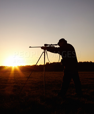 Buy stock photo Hunting at sunset, man with rifle stand in nature to hunt game for sport on safari adventure. Sky, silhouette and hunter with gun, focus on target and evening setting sun for shooting hobby in bush.