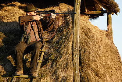 Buy stock photo Hut, hunter and man with gun on a safari at outlook post for animal and wild hunting. Male person, shooting and nature waiting for wildlife sports outdoor for scope watching at sunrise as a hobby