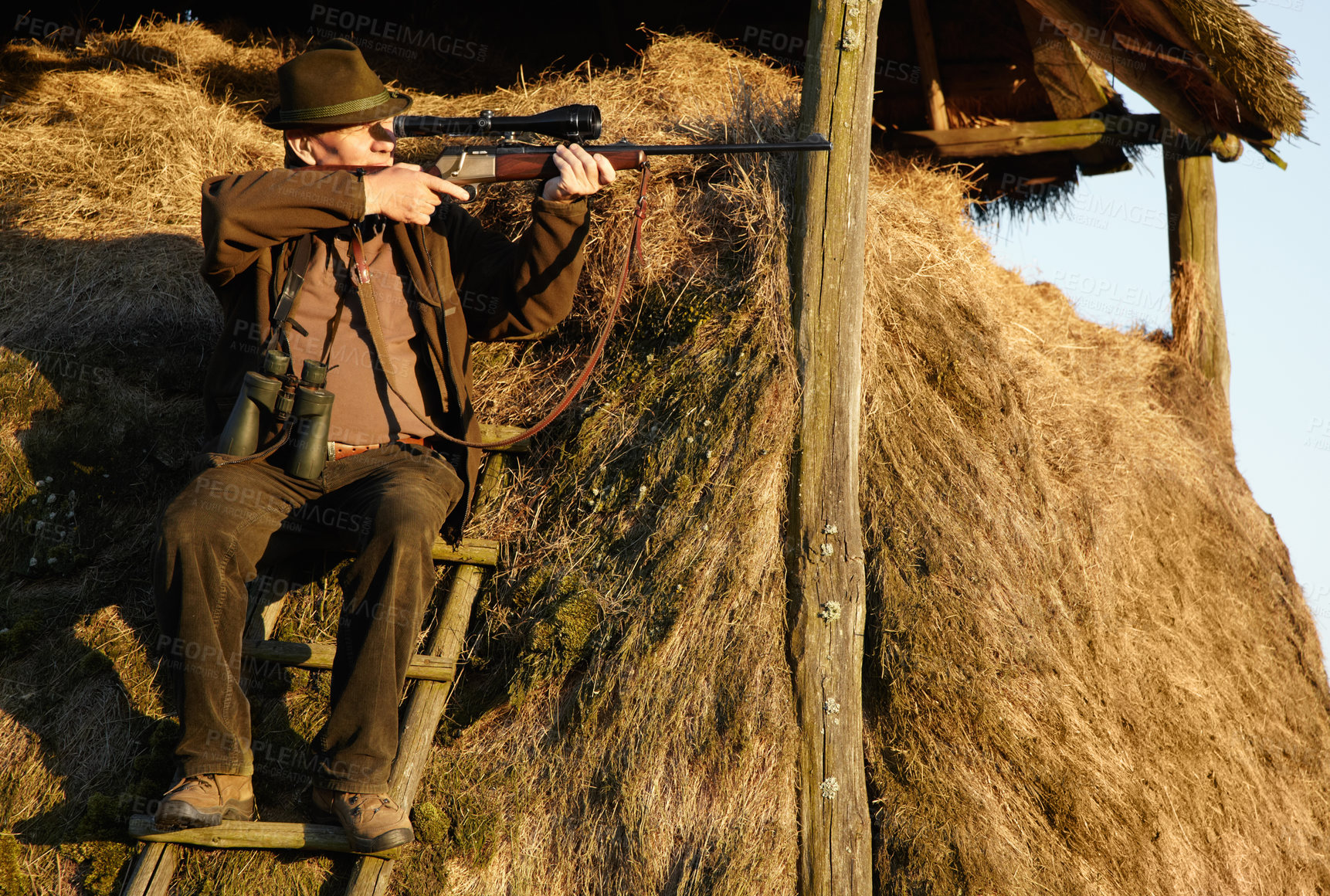 Buy stock photo Hut, hunter and man with gun on a safari at outlook post for animal and wild hunting. Male person, shooting and nature waiting for wildlife sports outdoor for scope watching at sunrise as a hobby