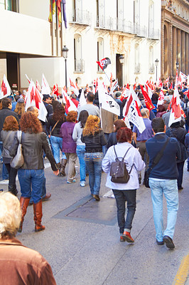 Buy stock photo Rearview shot of a group of protestors marching with flags