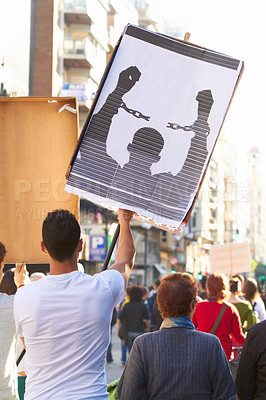 Buy stock photo Rearview shot of a group of protestors with placard describing freedom