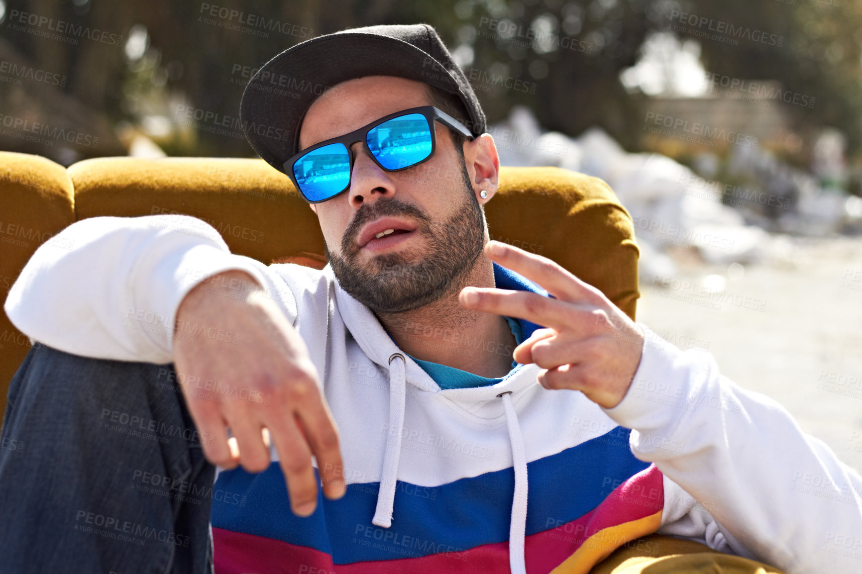 Buy stock photo Trendy fashion, portrait of a man with peace sign and sunglasses outdoors on couch. Freedom or youth, relax or hip hop and male person with emoji hand gesture for urban culture outside on sofa