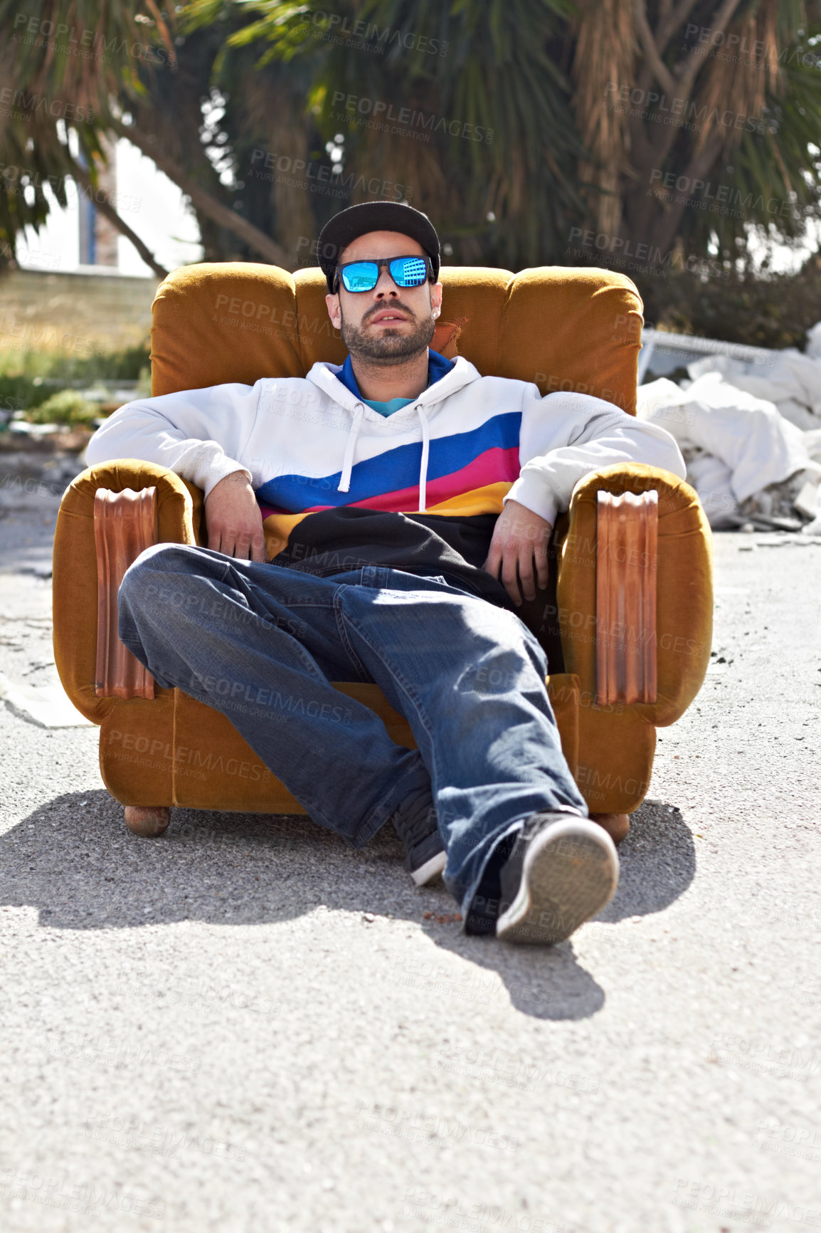 Buy stock photo Portrait, man with sunglasses and street or urban, fashion and relax with cool streetwear style in the city. Person, face and stylish model with cap relaxing, chair or outdoor couch and sofa