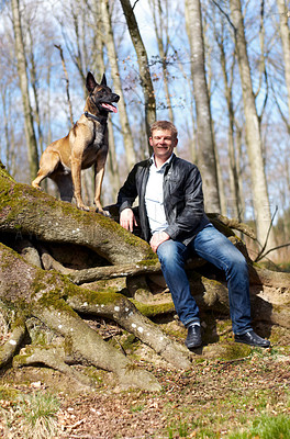 Buy stock photo A man and his dog sitting in the forest together