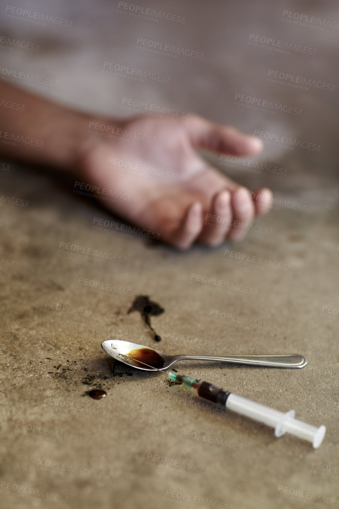 Buy stock photo Close up shot of a drug addicts limp arm with drug paraphernalia lying next to it