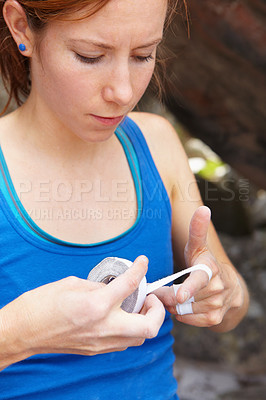 Buy stock photo Woman, hands and rock climbing or finger tape as grip strength, injury or support. Female person, band aid for safety rope challenge or danger adventure on stone cliff gear, brave risk on mountain