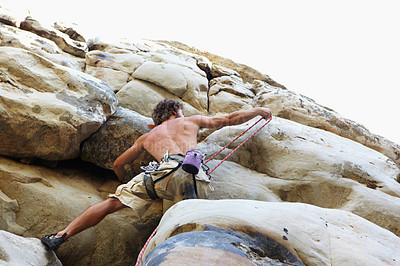 Buy stock photo Fitness, mountain and the back of a shirtless rock climber from below for freedom, adventure or adrenaline. Nature, sports and abseiling with a confident athlete climbing a cliff outdoor for action