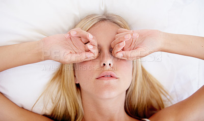 Buy stock photo A beautiful young woman rubbing her eyes while waking up in the morning