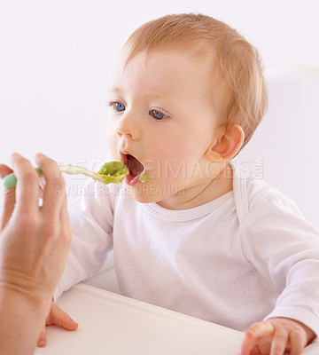 Buy stock photo A cute baby accepting a spoonful of food by his mom