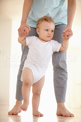 Buy stock photo Cropped image of the legs of a baby walking with a parent supporting from behind