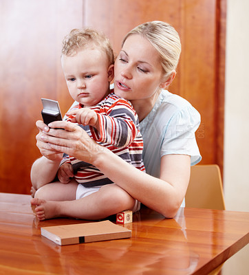 Buy stock photo A mother showing her child how a cellphone works