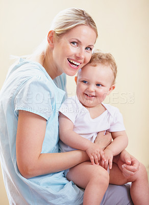 Buy stock photo A portrait of a smiling mother sitting with her child on her lap
