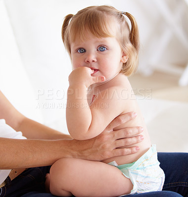 Buy stock photo Portrait, family and a girl baby on the lap of a parent closeup on the floor of a living room in their home. Kids, growth and child development with hands holding a cute young toddler in a diaper