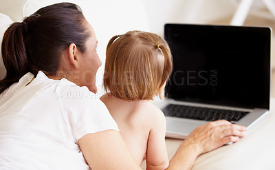 Buy stock photo A mother and her little daughter looking at a laptop together