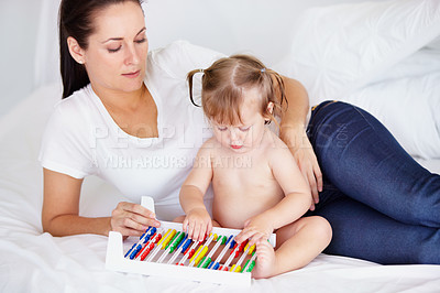 Buy stock photo Family, learning or abacus with a mother and baby on a bed in their apartment together for child development. Growth, education or math and an infant girl counting with her parent in a home bedroom