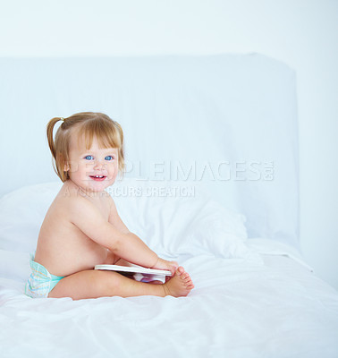 Buy stock photo Smile, learning and a baby with a book in the bedroom of a home for growth or child development. Kids, storytelling or reading with a happy young infant girl sitting on a bed in an apartment