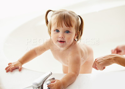 Smiling girl playing in water while taking bath with mother in bathtub at  home stock photo