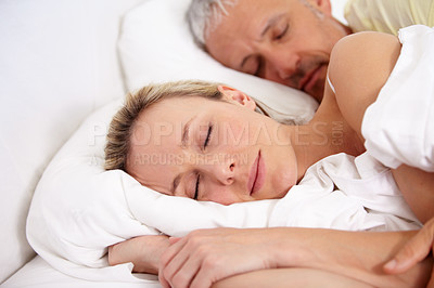Buy stock photo Love, tired and mature couple sleeping in bed for romantic cuddling together on weekend morning. Calm, peaceful and senior man and woman taking a nap in bedroom for bonding at modern apartment.