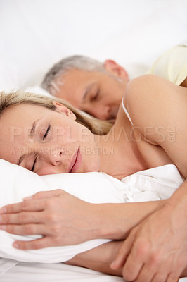 Buy stock photo Cropped closeup of a mature couple embracing while sleeping peacefully next to each other