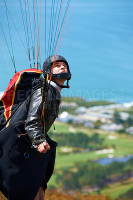 Buy stock photo Shot of a man paragliding on a sunny day