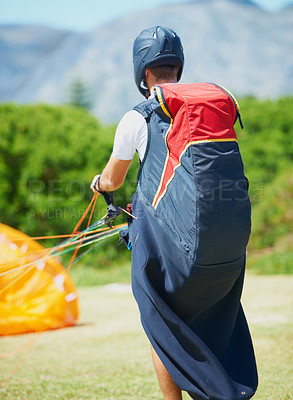 Buy stock photo Nature, man and parachute with ground for sport preparation, strings and training for paragliding exercise. Person, safety gear and helmet for outdoor fitness with toggle, fearless and countryside