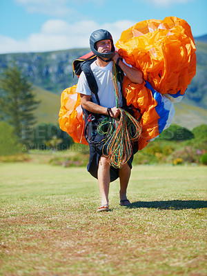 Buy stock photo Shot of a man carrying his paragliding equipment