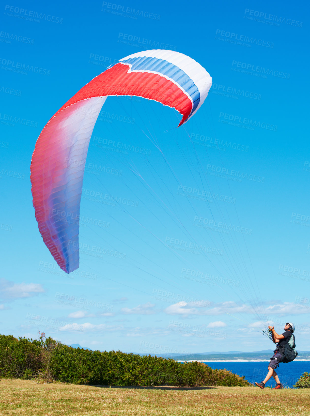 Buy stock photo Man, parachute and paragliding launch in nature with safety training, healthy adventure and extreme sport. Person, strings and flying skill for outdoor fitness with helmet and  blue sky for wellness