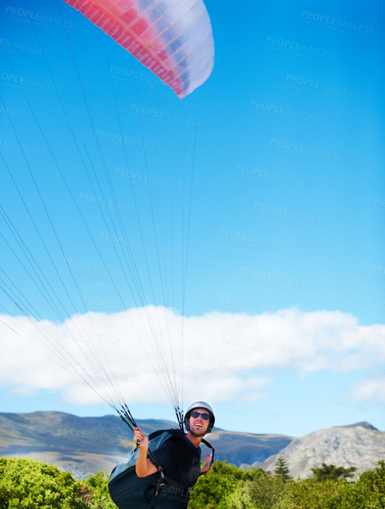 Buy stock photo Man, parachute or paragliding sport in preparation exercise, healthy adventure or extreme fitness. Person, launch or fearless for outdoor flight in health wellness, helmet or safety gear by blue sky