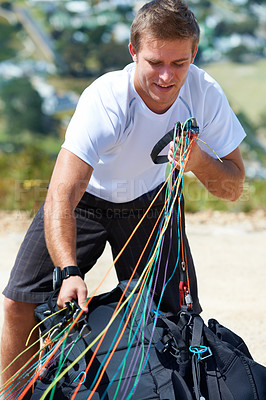 Buy stock photo Man, safety harness or paragliding sport in launch in training, healthy adventure or extreme fitness. Person, preparation and fearless outdoor for flight with smile and parachute gear in countryside