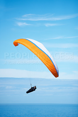 Buy stock photo Shot of a man paragliding on a sunny day