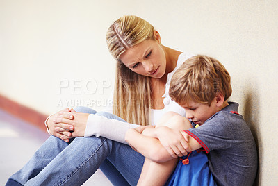 Buy stock photo Teacher, sad student and talking at school for support, trust or counselling. A woman working with a child for discussion or education about bullying, learning problem and development in hallway