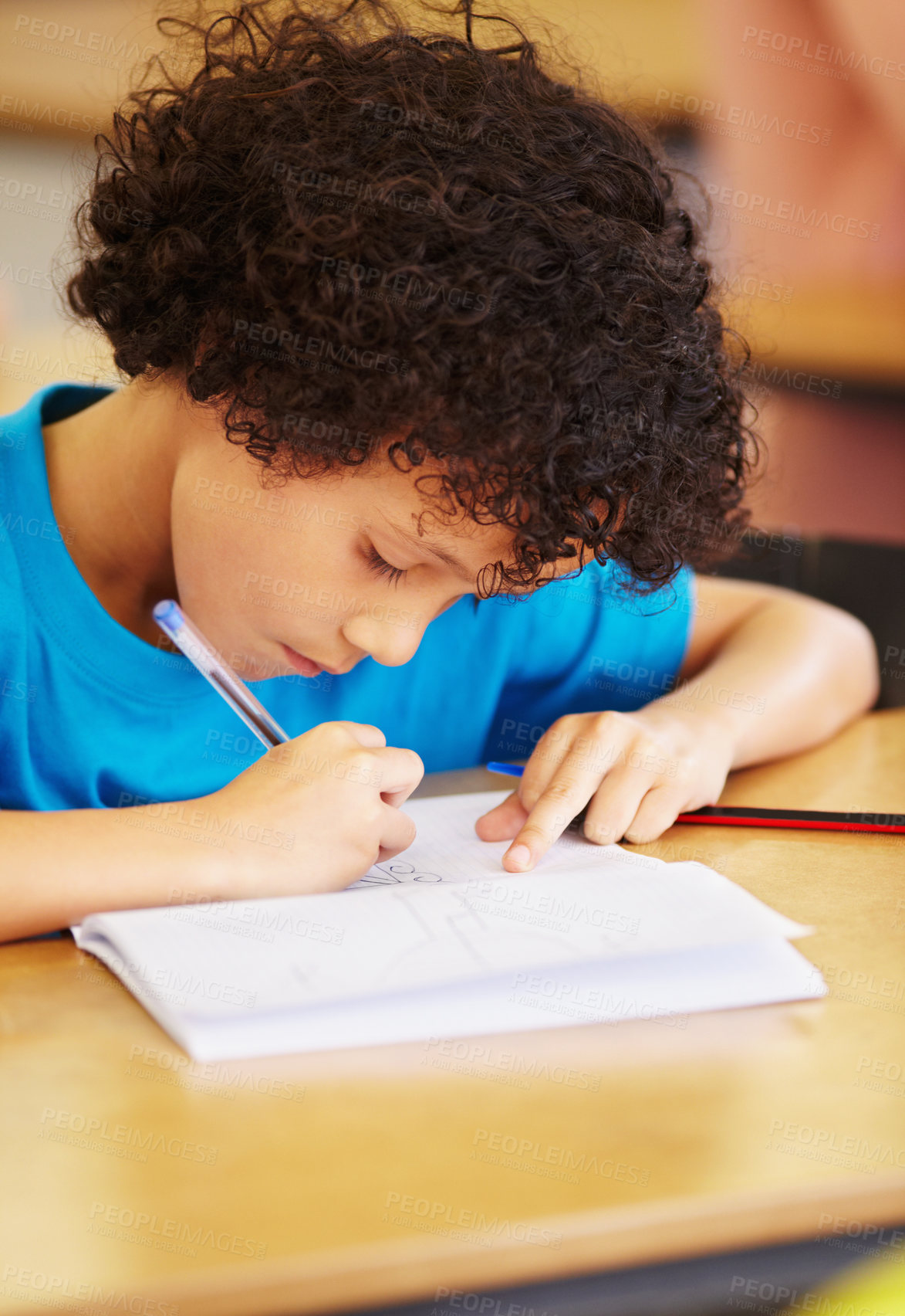 Buy stock photo Boy kid, school and writing test in classroom with focus, concentration or thinking for education goals. Male child, book and pen in class for assessment, studying or learning at desk for development