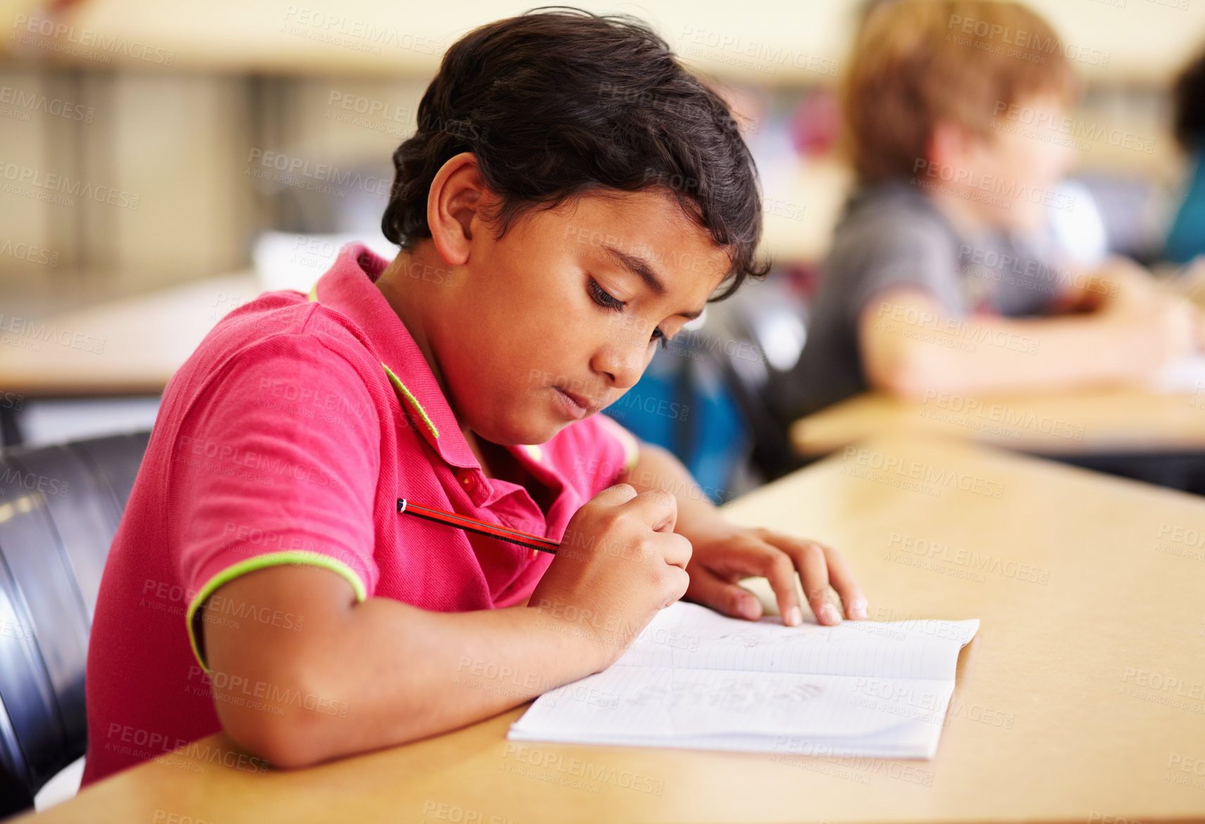 Buy stock photo Education, student and boy in a classroom, writing and studying for a test, exam and notebook. Male child, school and kid with a book, pencil and creative with development, growth and learning