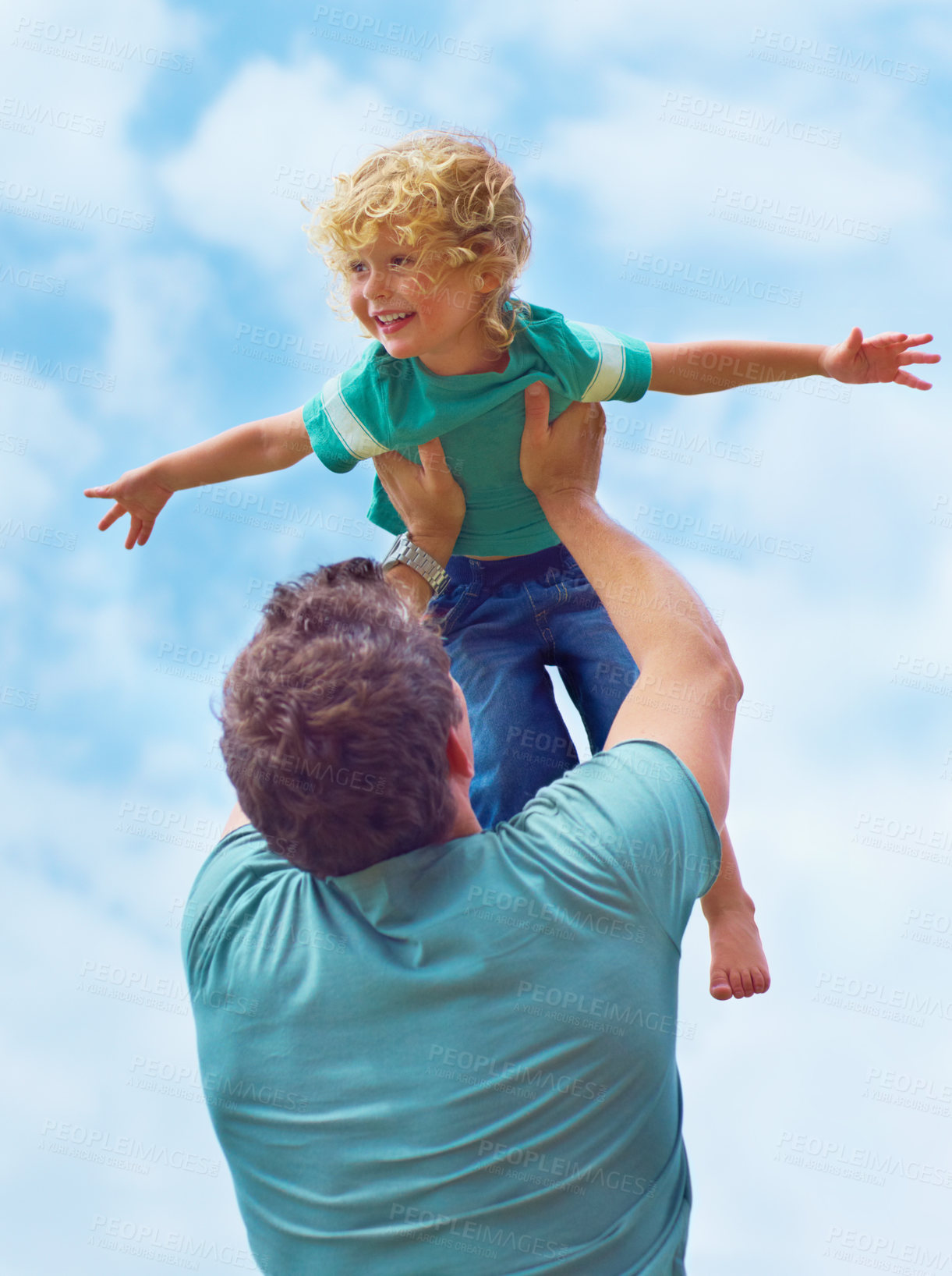 Buy stock photo A father swinging his toddler son in the air against a sky background